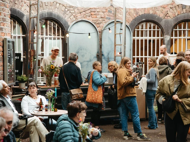 Sommerfest des Fort Paul e.V. Besucher beim Sommerfest im Fort Paul vor Backsteinmauern, Lichterketten und Getränkestand