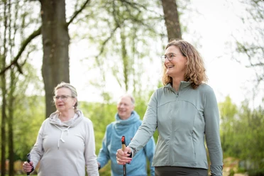 Nordic Walking Gruppe Gesundwerk Bad Salzuflen.jpg Zwei Frauen und ein Mann auf einer Nordic-Walking-Runde durch den Kurpark