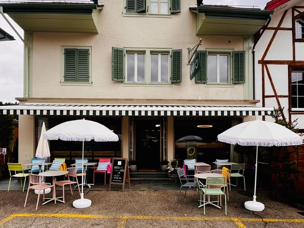 WiVA coffee & more Aussenansicht des Cafes WiVA Coffee and more in Willisau mit Sitzplätzen und Sonnenschirmen vor dem Gebäude