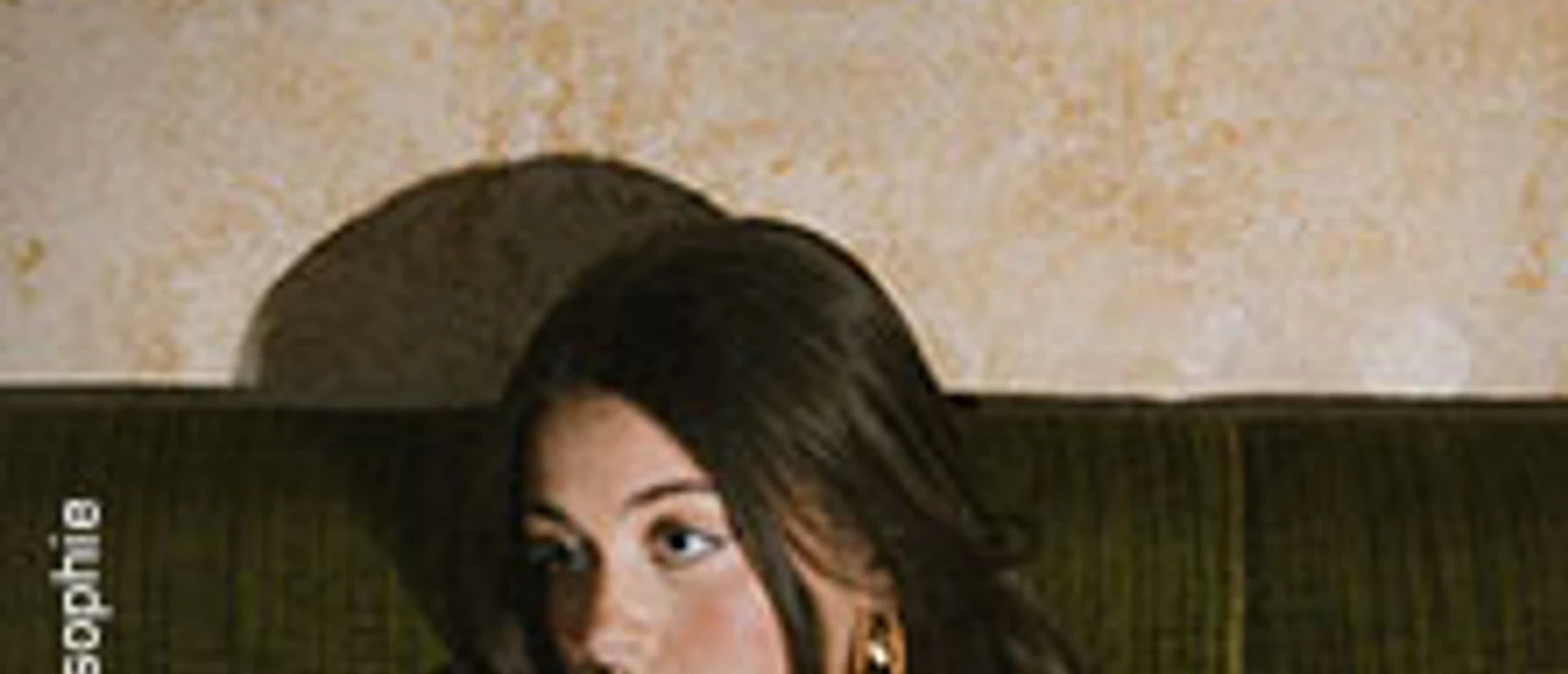 Tourplakat von Charlotte Kudella mit Porträt der Künstlerin vor grünem Sofa