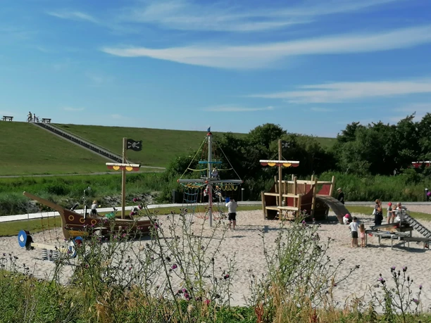 Spielplatz Trockenstrand Upleward Sandspielplatz am Trockenstrand Upleward mit Piratenschiffen, Kindern und Deich