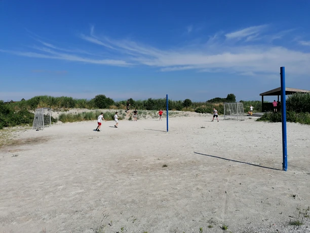 Trockenstrand Beach-Soccerfeld Sandfläche am Trockenstrand Upleward mit Kindern beim Fußballspielen und blauen Spielpfosten