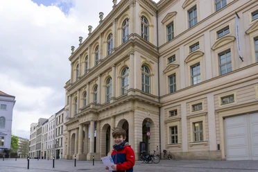 Kinderführung Barberini.jpg Ein Junge steht vor dem Museum Barberini mit einem Rätselheft in der Hand.