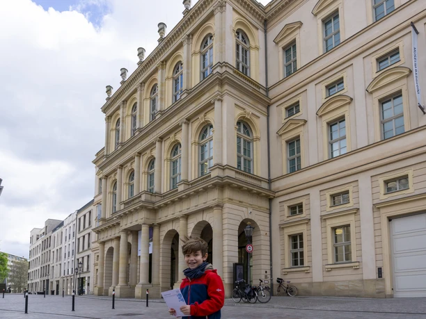 Kinderführung Barberini.jpg Ein Junge steht vor dem Museum Barberini mit einem Rätselheft in der Hand.
