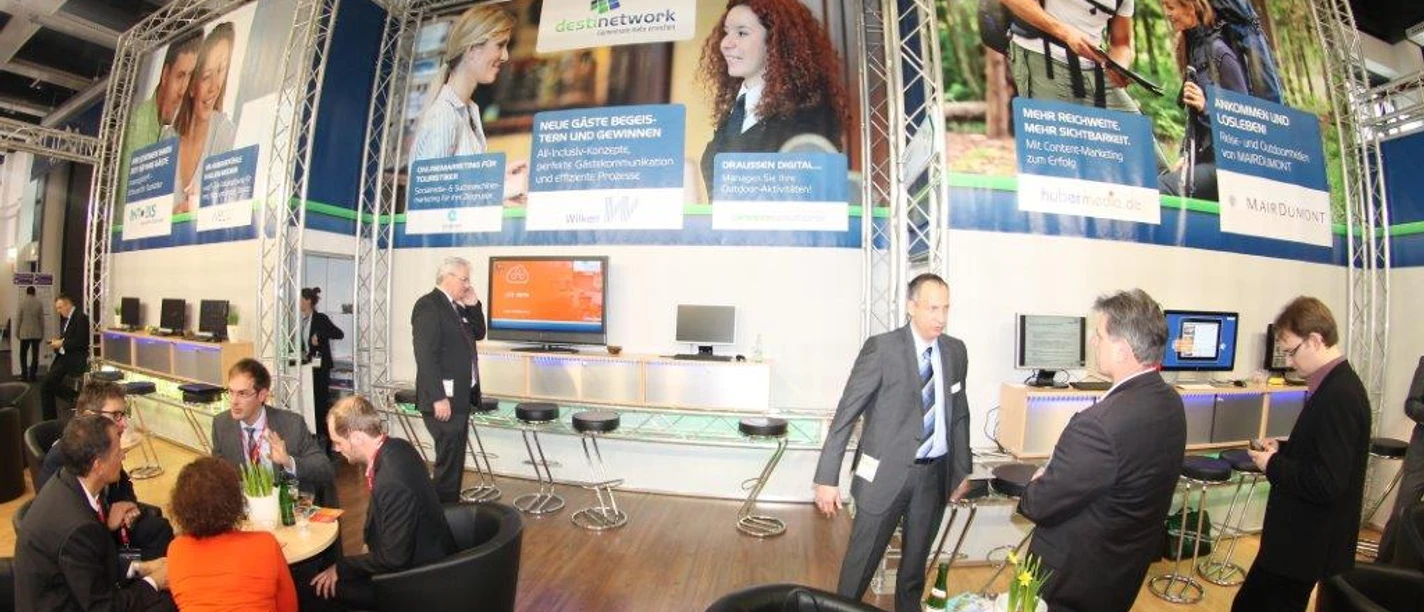 ITB 2008 Messestand mit Gesprächsgruppen, Bildschirmen und großer Werbebande.