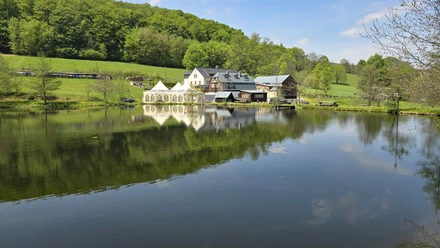 See mit Häusern, Wiese und Wald
