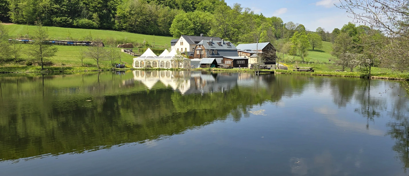 See mit Häusern, Wiese und Wald