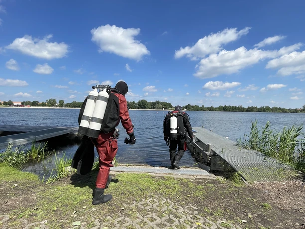 Zwei Taucher auf dem Weg ins Wasser.