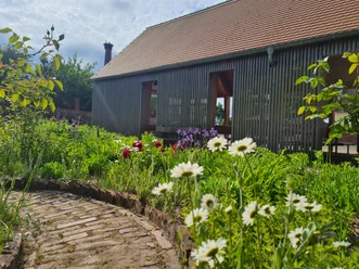 Park Canitz in Thallwitz - Erholung in der Region Leipzig Blick auf ein Holzhaus mit Blumenbeet