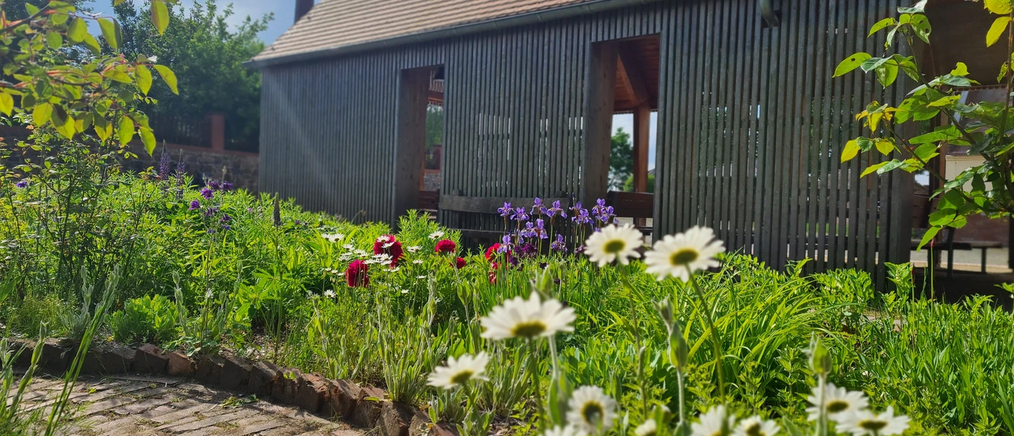 Park Canitz in Thallwitz - Erholung in der Region Leipzig Blick auf ein Holzhaus mit Blumenbeet