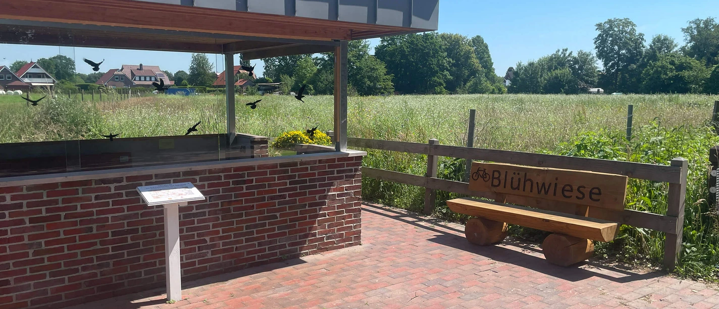 Schutzhütte mit Holzbank an einer Blühwiese an der Fahrradstraße Bad Zwischenahn.