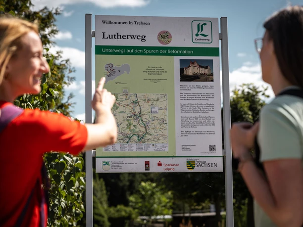 dwie turystki patrzą na tablicę informacyjną przy szlaku Lutra