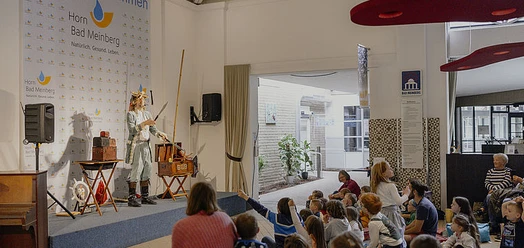 Kindertheater im Haus am Kurpark mit Darsteller auf der Bühne und Kindern im Publikum
