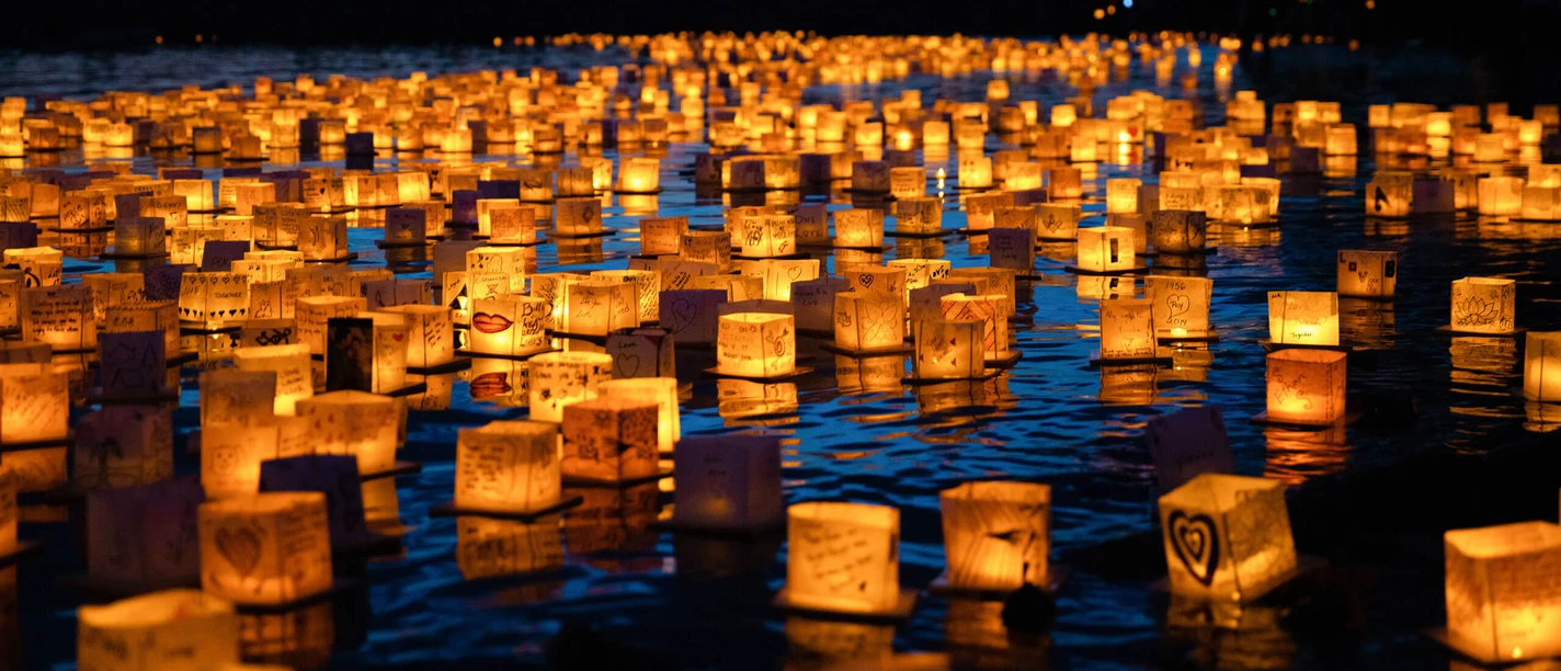 Water Lantern Festival Glowing water lanterns float across a lake at dusk