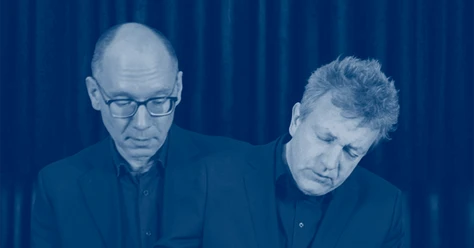 Tobias Koch und Benjamin Kobler Zwei konzentrierte Musiker in dunklen Anzügen vor blauem Bühnenvorhang