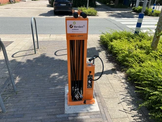 Fahrradstation Reeperbahn Verden (2).jpeg Orange Fahrradreparaturstation mit Werkzeug und Luftpumpe an einem Gehweg in Verden.