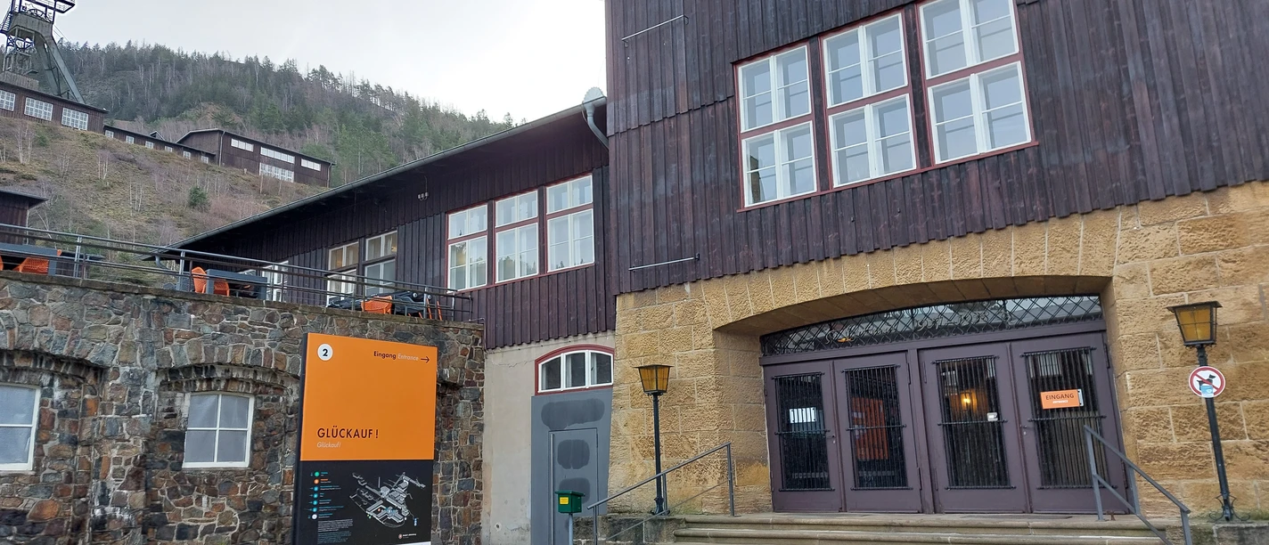 The entrance to the Rammelsberg Museum, featuring an orange information board and a historic building.