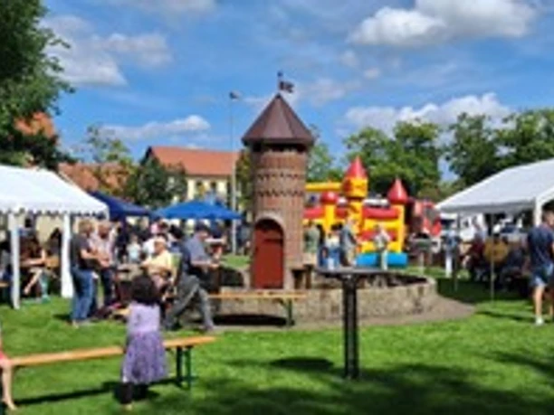 Sommerfest beim OBV Apen.jpeg Sommerfest mit Zelten, Familien, Spielturm und Hüpfburg auf dem Platz.