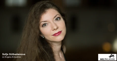 Sofja Gülbadamova Porträt der Pianistin Sofja Gülbadamova mit langem Haar vor dunklem Hintergrund