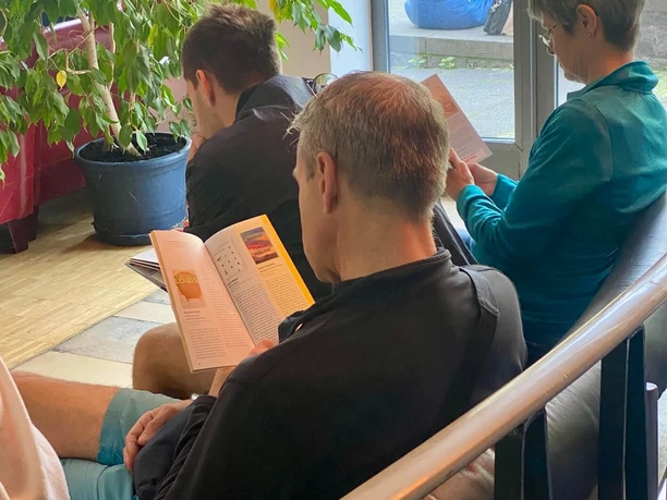 Visitors browse program booklets at the Cologne Book Festival at the Stollwerck Community Center