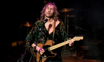 Ralph de Jongh.jpg Ralph de Jongh singt auf der Bühne und spielt E-Gitarre im Scheinwerferlicht.