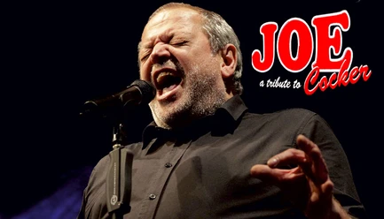 Joe Cocker Tribute.jpg A singer at the microphone during the Joe Cocker tribute concert, with a red "JOE" logo next to him.