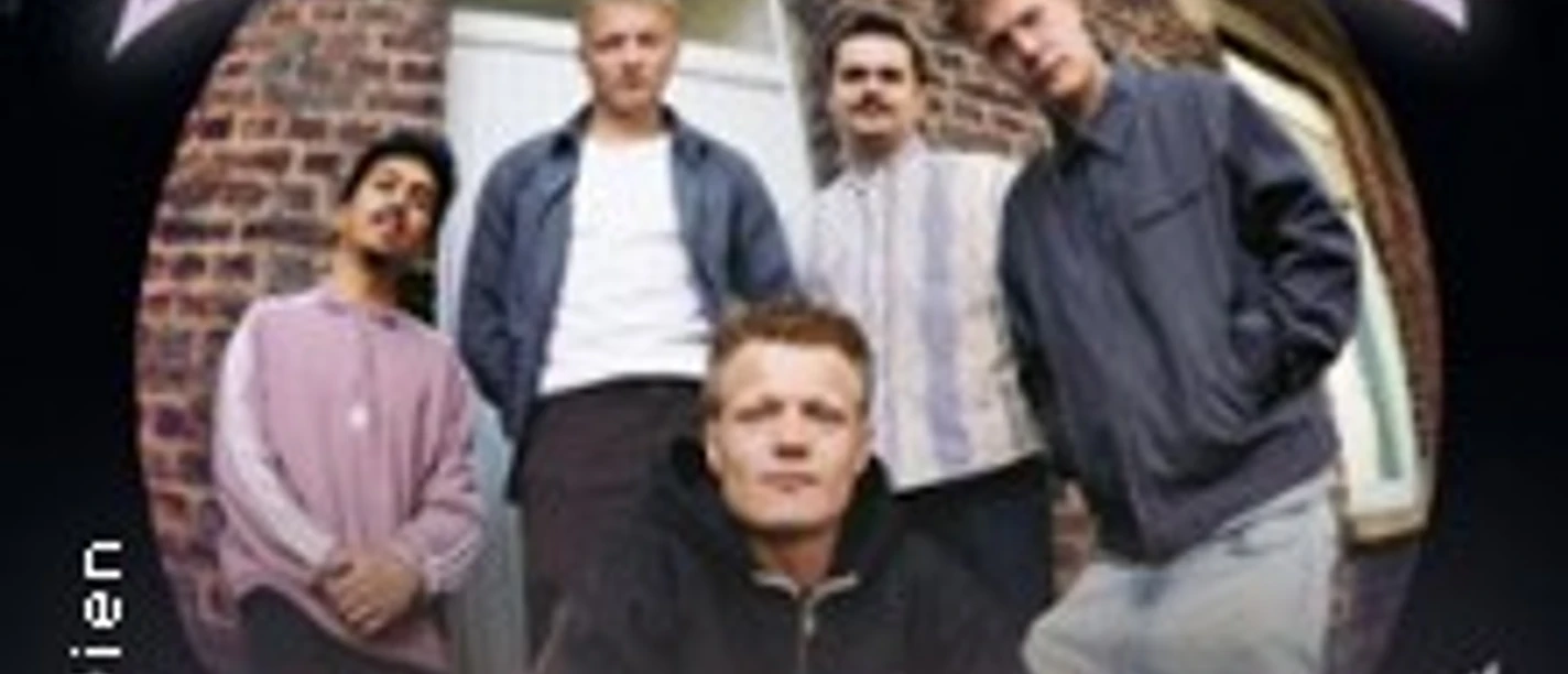 Fünf Musiker der Band Bruchbude vor Backsteinwand mit Schriftzug „Nichts zu verlieren“