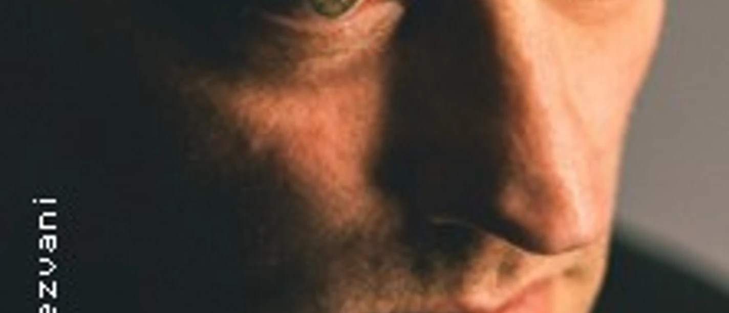 Nahaufnahme eines Mannes mit ernstem Blick, warmem Licht und dunklem Hintergrund