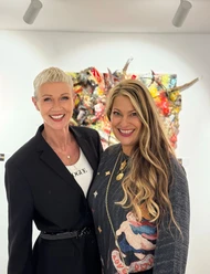 Andrea Wycisk & Manuela Klein.jpg Andrea Wycisk und Manuela Klein lächelnd vor farbenfroher Upcycling-Kunst.