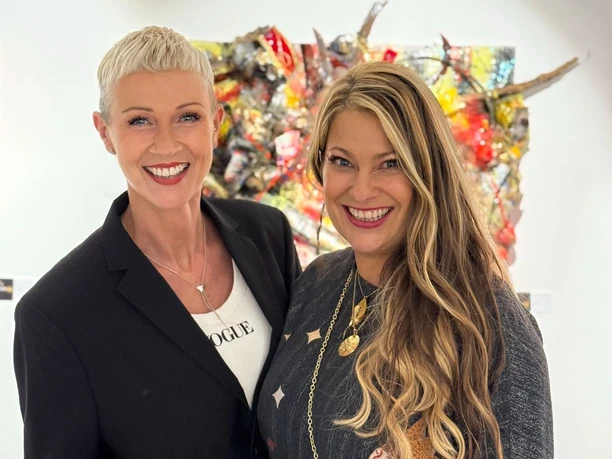 Andrea Wycisk & Manuela Klein.jpg Andrea Wycisk und Manuela Klein lächelnd vor farbenfroher Upcycling-Kunst.