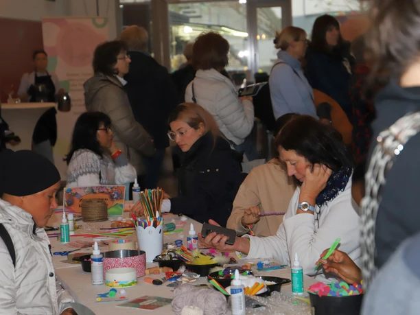 Kreativtisch auf der Frauen*Kraft Frauen basteln an einem Kreativtisch beim Begegnungsfest Frauen*Kraft.