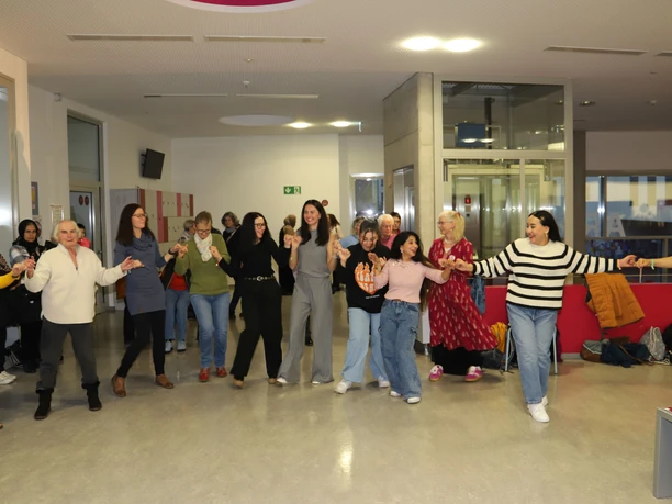Hand in Hand Frauen tanzen Hand in Hand bei der Veranstaltung Frauen*Kraft im Medienhaus.