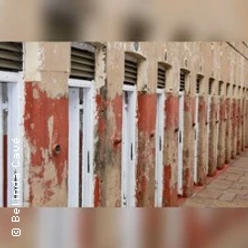 Reihe verwitterter Spinde mit abblätternder roter Farbe in einem Flur