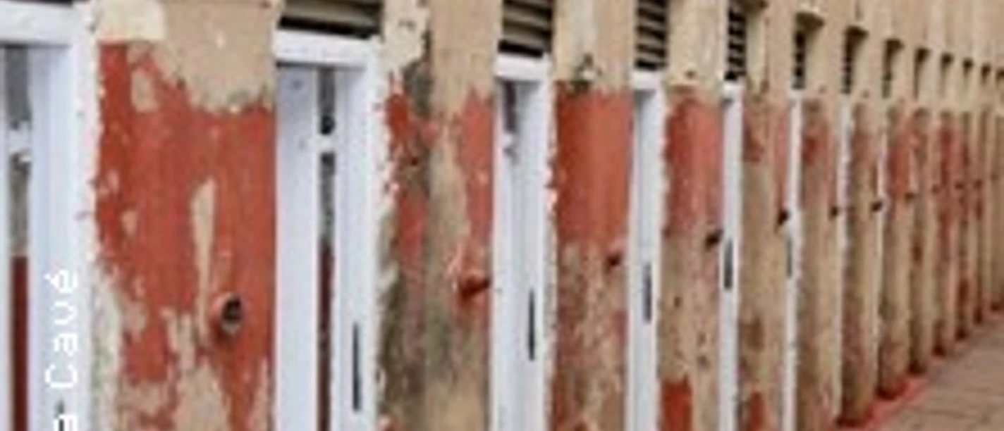 Reihe verwitterter Spinde mit abblätternder roter Farbe in einem Flur