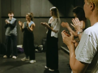 ritual: Musik, Spaziergänge und Community Teilnehmende klatschen im Kreis bei einer Ritual-Musikveranstaltung in Köln