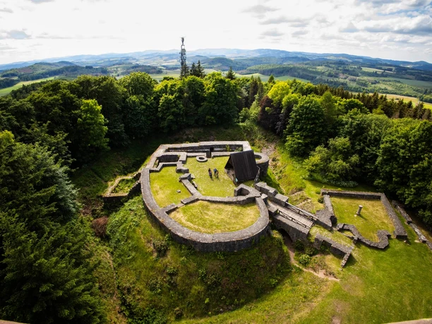 Luftaufnahme des Eisenbergs bei Korbach mit Burgruine und Georg-Viktor-Turm auf dem bewaldeten Gipfel, umgeben von der Korbacher Hochfläche und der Berglandschaft des Sauerlands