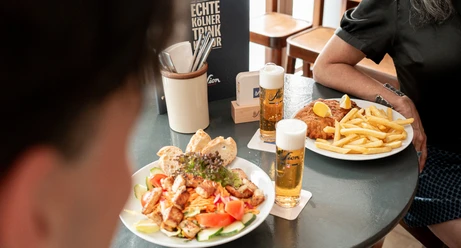 Stapelhaus Kölsch, salad, and schnitzel with fries on a table at the Stapelhaus in Cologne