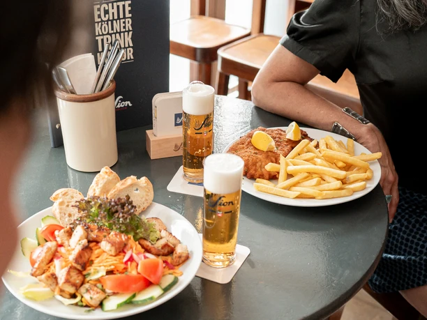 Stapelhaus Kölsch, salad, and schnitzel with fries on a table at the Stapelhaus in Cologne