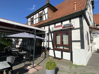 Gameiro_Außenansicht.jpg Restaurant Gameiro in einem Fachwerkhaus mit Außengastronomie und Sonnenschirm.