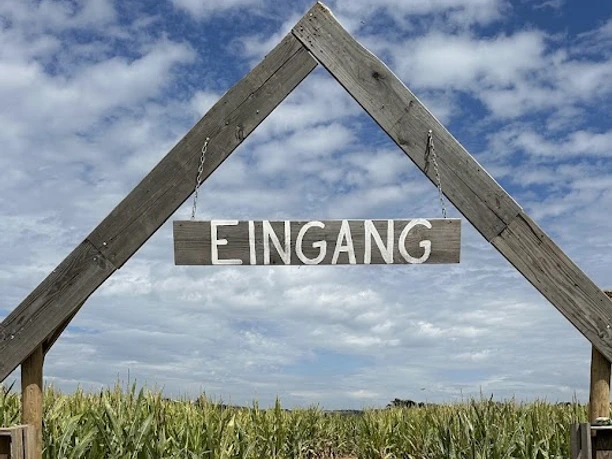 Eingangsportal aus Holz zum Maislabyrinth