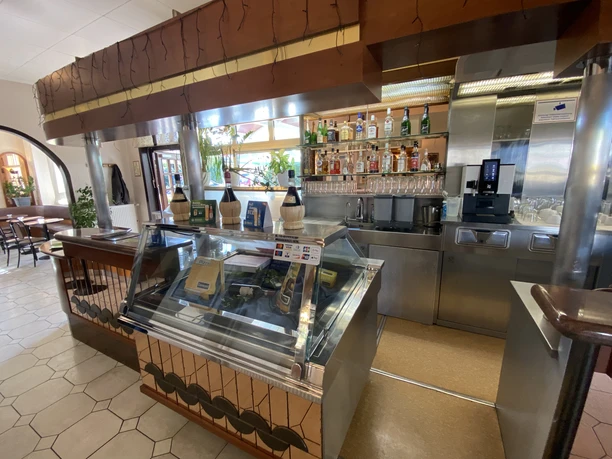 Theke mit Glaskühlvitrine und Barregalen mit Getränken im Gameiro Pizza-Service.