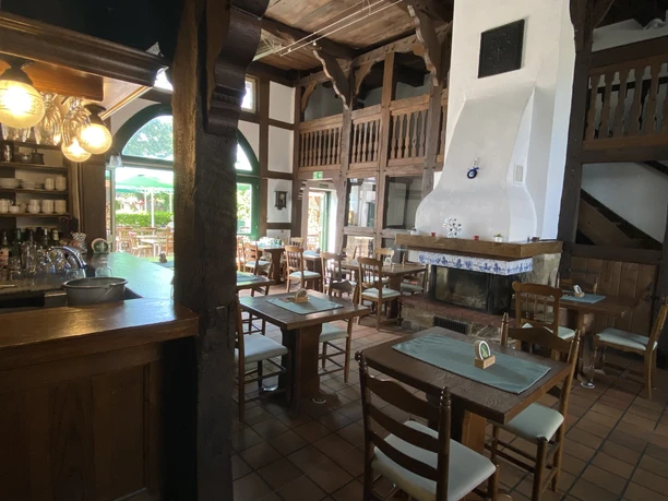 Meteora_Pr.Oldendorf_Innenansicht.jpg Gastraum des griechischen Restaurants Meteora mit Holzbalken und weißem Kaminofen.
