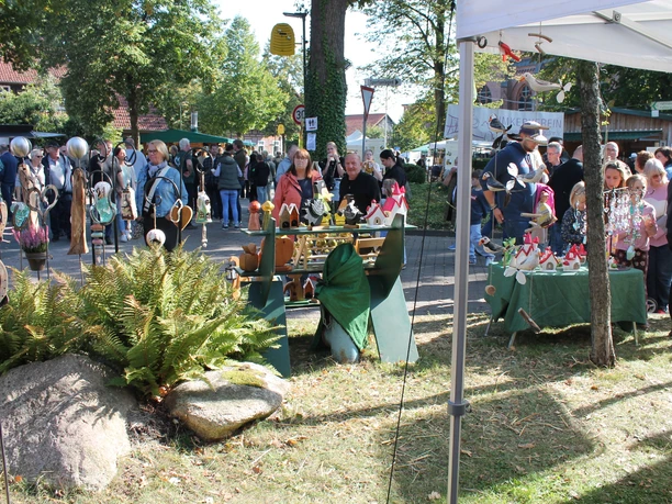A well-attended arts-and-crafts booth at the Honey Festival under the trees in Wietzendorf.