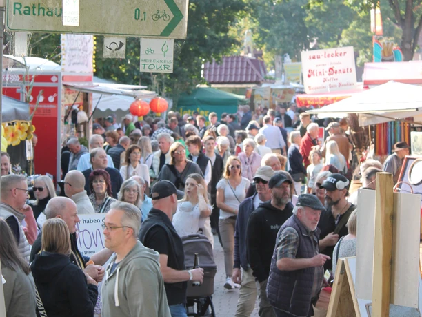 A bustling Marktstraße during the Honey Festival in Wietzendorf, lined with booths and signs.