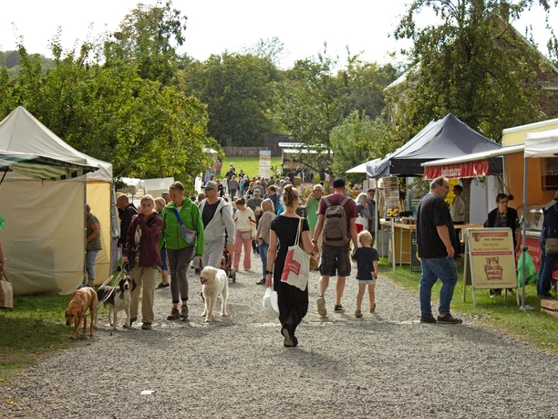 Besucher schlendern mit Hunden zwischen Marktständen beim Bauernmarkt in Lindlar