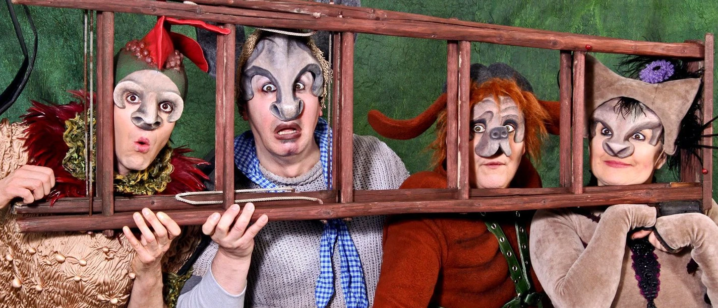 Kostümierte Schauspieler als Bremer Stadtmusikanten mit einer Holzleiter im Theater Espelkamp.