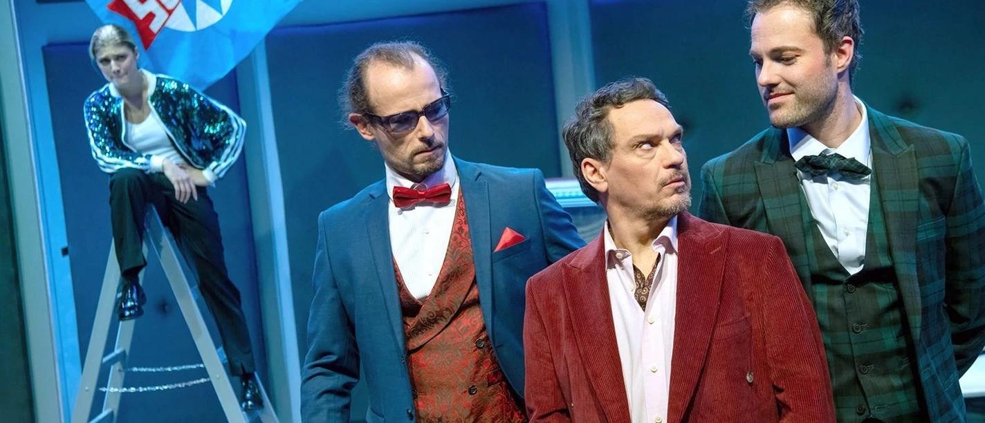 Vier kostümierte Darsteller der Komödie Pension Schöller auf einer Theaterbühne.
