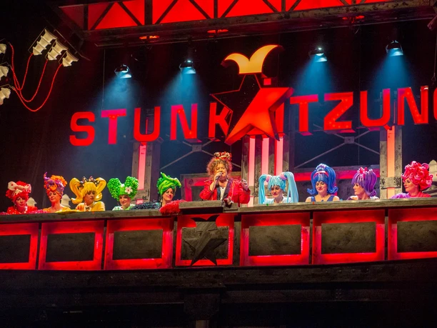 Stunksitzung: a cabaret-style show during Cologne's Carnival The stage of the Stunksitzung, featuring costumed performers beneath red lettering.