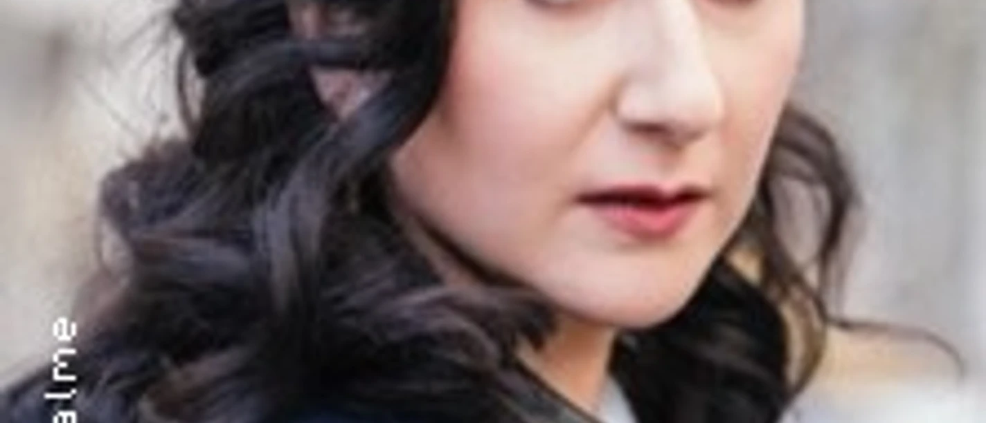 Porträt von Carolin Karnuth mit dunklen Locken und schwarzer Lederjacke