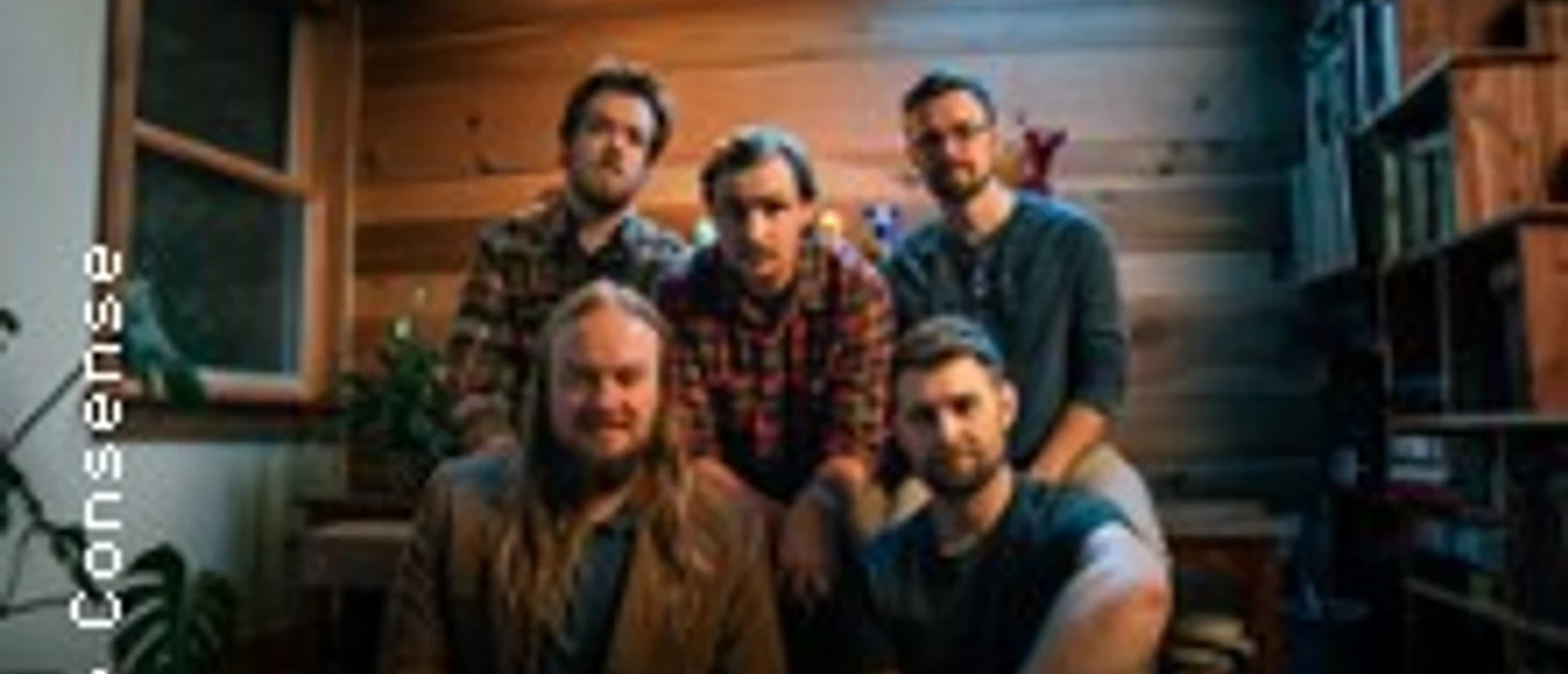 Fünf Musiker von Tophouse with Raynes in einem warm beleuchteten Raum